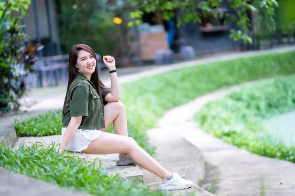 在公园的背景下 一个美丽而快乐的亚洲女性游客身穿浅绿色连衣裙 时尚时尚的嬉皮士 夏日阳光灿烂的生活方式在户外街道上的肖像 — 图库照片