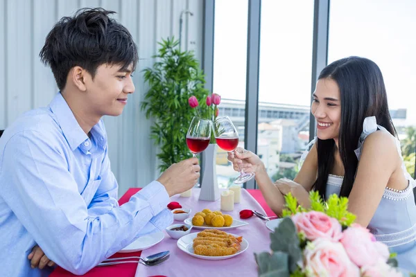 バレンタインデーのコンセプト 幸せなアジアの若い甘いカップルは レストランの背景にあるワイングラスをクリックしてランチをロマンチックにしています — ストック写真