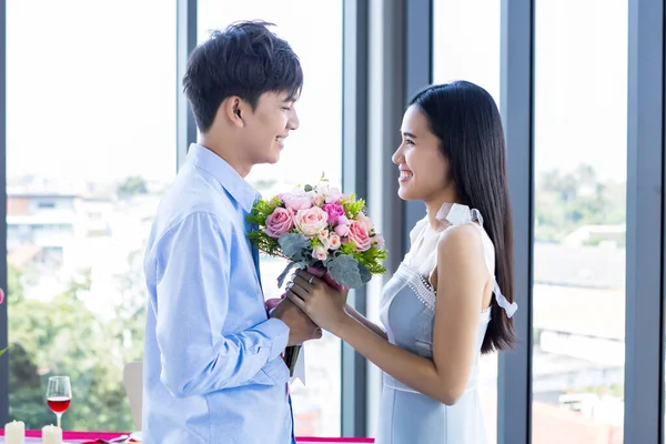 バレンタインデーのコンセプト アジアの若い幸せな甘いカップルが赤とピンクのバラの花束を持って昼食後レストランの背景で 愛の物語のカップル — ストック写真