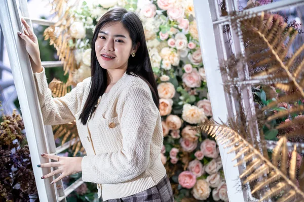 笑顔幸福の肖像画室内やカフェで暖かい服を着ている美しい若いアジアの女性とバラの背景 — ストック写真