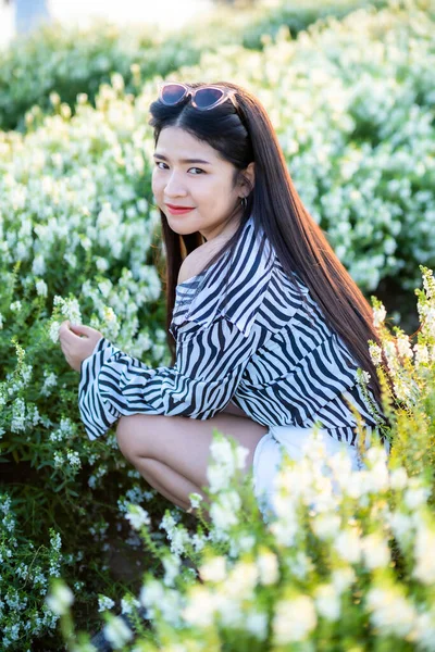 在泰国大自然的花园里 穿着黑白花纹服装的亚洲年轻女子快乐旅行 享受着白花盛开的田野 旅行放松 — 图库照片