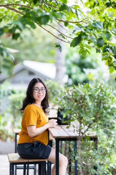 夏天的时候 在公园或咖啡店的背景下 一位美丽而快乐的亚洲女人穿着黄色橙色衣服 时尚时髦 生活在街上的画像 — 图库照片