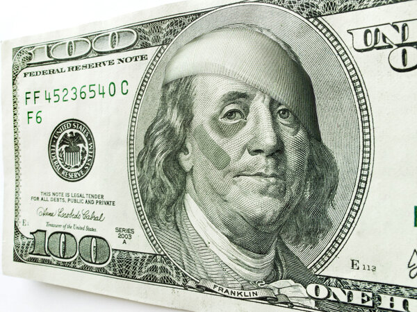 Ben Franklin with black eye and bandages on one hundred dollar bill illustrates many economic concepts and ideas.