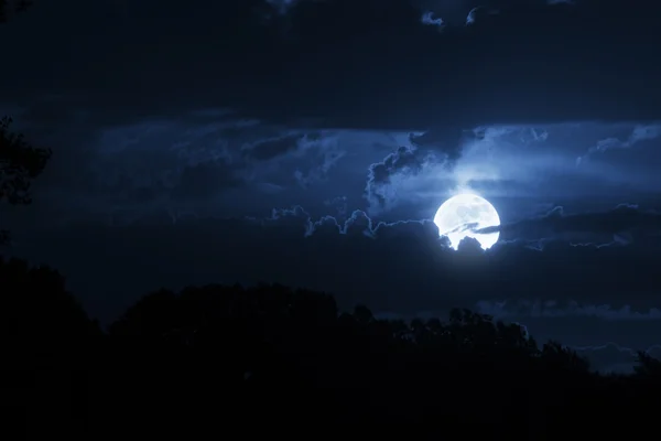 Dramáticas nubes nocturnas y cielo con hermosa luna azul llena — Foto de Stock