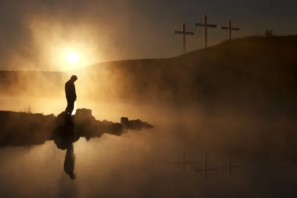 El sol de la mañana y la niebla rodean al caminante con siluetas en un lago tranquilo — Foto de Stock