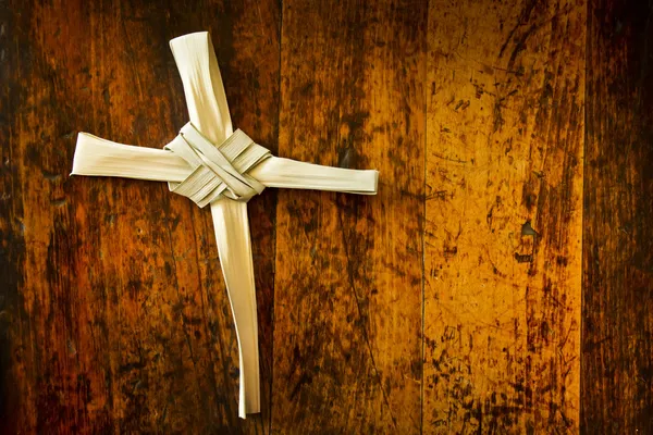 Croce fatta dal ramo Domenica delle Palme sulla vecchia panca di legno — Foto Stock
