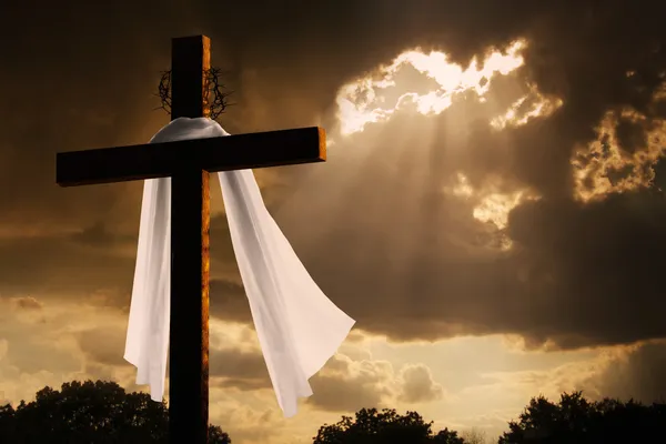 Iluminación dramática en la cruz cristiana de Pascua mientras las nubes de tormenta se rompen — Foto de Stock