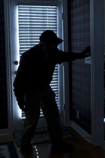 Inbreker breken naar huis bij nacht via achterdeur — Stockfoto