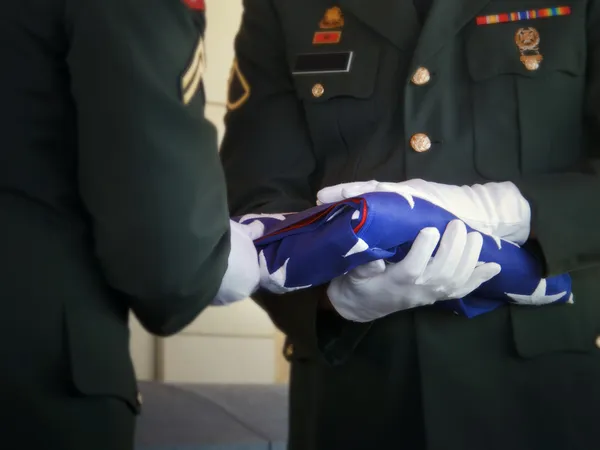 Militära honor guard veck USA flaggan på veteran begravning Stockbild