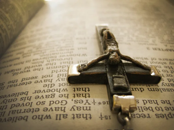 Croix faite à la main couchée sur une page biblique — Photo