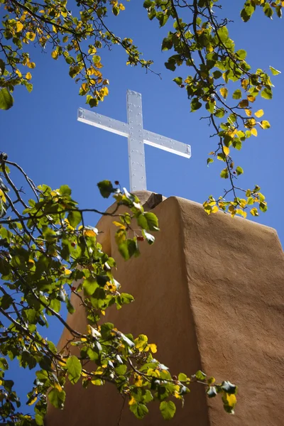 Cross glows brightly atop a mission building — Stock Photo, Image