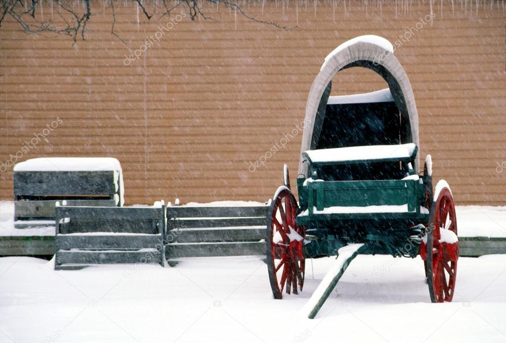 Old wagon sits idle in the winter snow