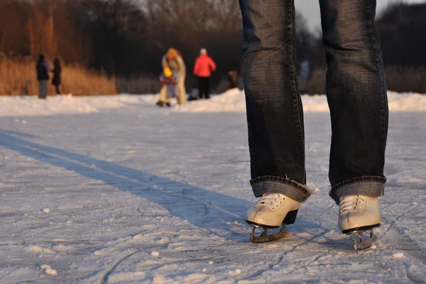 Closeup woman legs in white ice skates — Stock Photo, Image