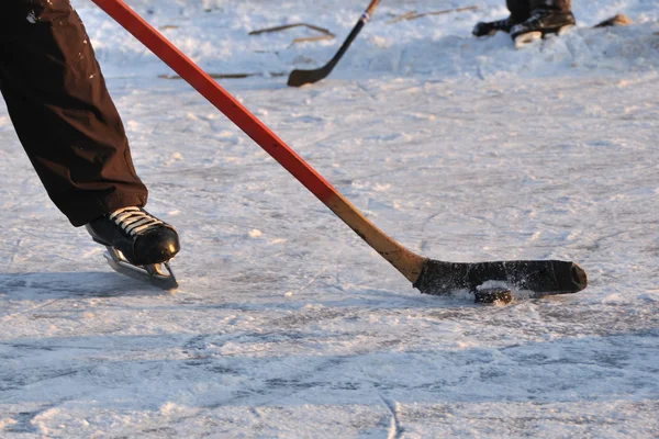 Hockey stick and ice skate in fragment of leisure hockey game Stock Image