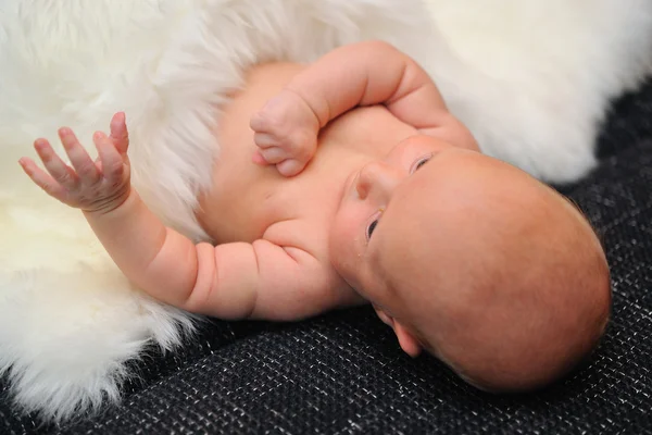Pasgeboren baby dekking door witte vacht — Stockfoto