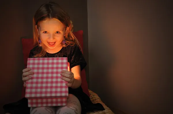 Kleines Mädchen öffnet magisches Geschenk — Stockfoto