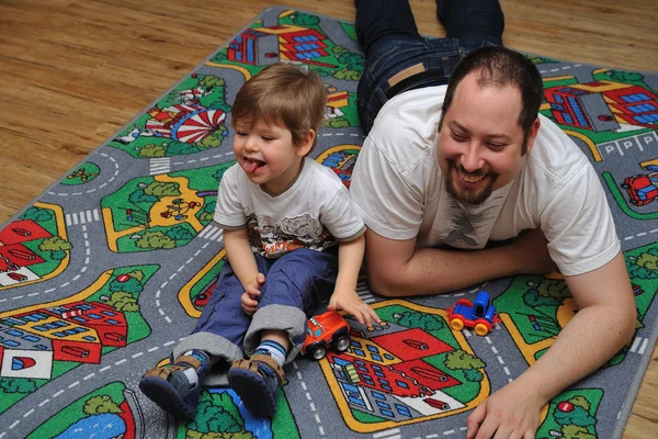 Fils et père jouant avec des jouets sur le tapis — Photo