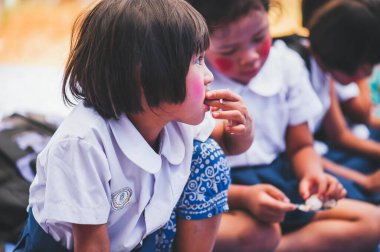 MAE HAI OMKOI CHIANG MAI, THAILAND - 10 HAZİRAN 2019: Çocuklar Chiang Mai, Tayland 'daki bağışlardan gelen lezzetli bir yemeğin tadını çıkarıyorlar