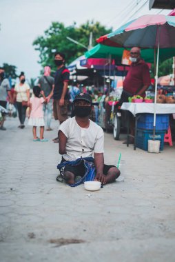 CHIANG MAI, THAILAND - 5 Temmuz 2021: Sakat kolları ve bacakları olan dilenci para ve eşya bağışlarını Chiang Mai, Tayland 'daki bit pazarında talep ediyor