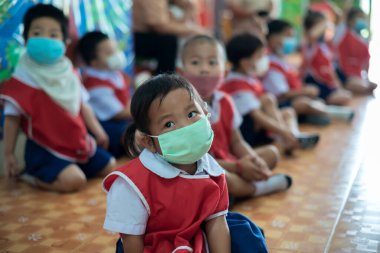 CHIANG MAI, THAILAND - 23 Mart 2021: Taylandlı çocuklar Chiang Mai, Tayland 'daki anaokulunda toz ve mikropları önlemek için maske takıyorlar.