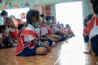 CHIANG MAI, THAILAND - 23 Mart 2021: Taylandlı çocuklar Chiang Mai, Tayland 'daki anaokulunda toz ve mikropları önlemek için maske takıyorlar.