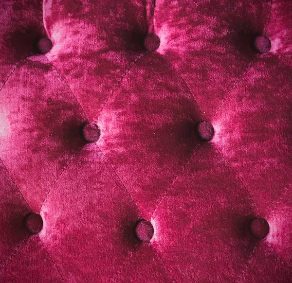 The back of the sofa chair is made of pink velvet fabric.