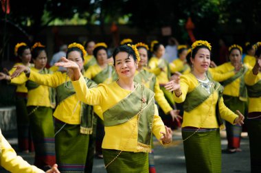 CHIANG MAI, THAILAND - 11 Kasım 2018: Geleneksel erdem festivalinde sarı kumaş giymiş Asyalı kadınlar dans ediyor. Chiang Mai, Tayland 'da