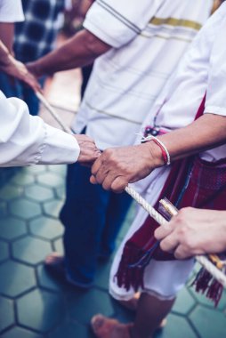 İnsanlar birbirlerine güç ve birlik içinde halatı çekmede yardım ederler: takım çalışması kavramı..
