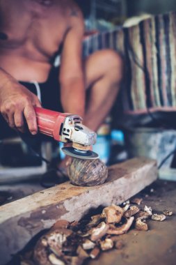 Using electric blades to sharpen coconut shells to be smooth.