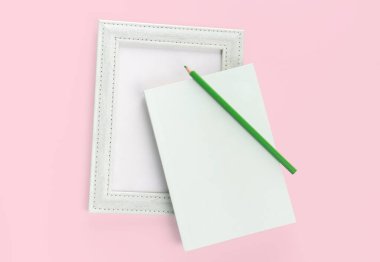 düz yeşil kitap kırtasiyesi ve pembe arkaplan üzerindeki resim çerçevesi