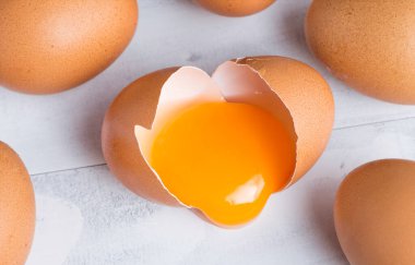 Çiğ tavuk yumurtası, yumurta sarısı kabuklu beyaz ahşap