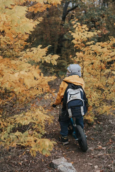 Boy on a balance bike ride in the autumn forest — Stock Photo, Image