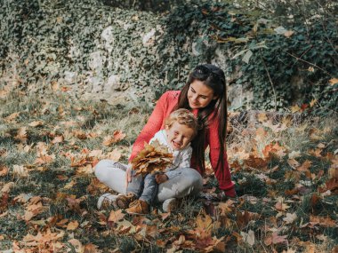 Anne ve oğlu çimlerin üzerinde sarılıyorlar..
