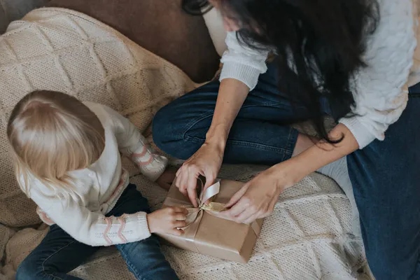 Маленька дівчинка і її мати відкривають різдвяний подарунок . — стокове фото