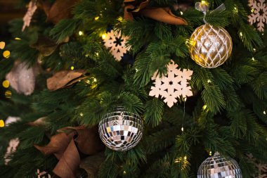 Altın renkli süslemeleri olan yeşil Noel ağacı.