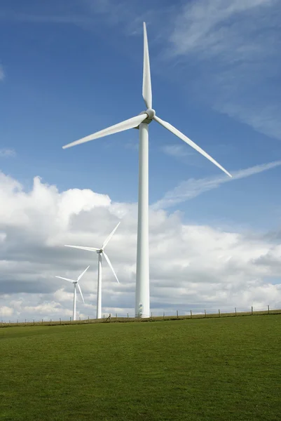 Drie elektriciteit genereren windmolens op een landelijke heuvel — Stockfoto