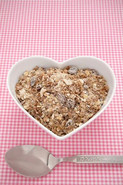 Muesli i en hjerteformet bolle – stockfoto