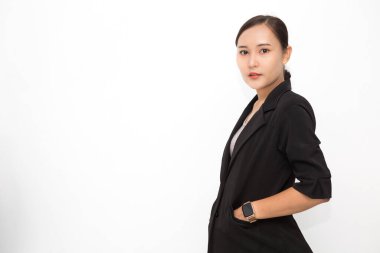 Beyaz arka plan ve fotokopi alanında eli takım elbiseli, siyah takım elbiseli güzel Asyalı bir iş kadını. Kendine güvenen Asyalı çalışan kadın gülümsüyor ve neşeli.