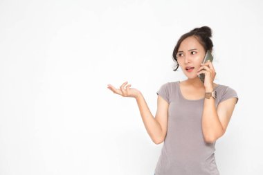 Güzel Asyalı kadın beyaz arka plan ve fotokopi alanında elinde akıllı telefonla gri bir gömlek giyiyor. Tatlı Asyalı kadın, telefonda sosyal medya konseptiyle ilgili bir şeyler konuşmanın altını çizmiş.