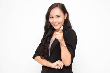 Siyah takım elbiseli güzel Asyalı iş kadını kamerayı işaret ederek beyaz arka plan ve fotokopi alanında bir şey sunuyor. Kendine güvenen Asyalı çalışan kadın gülümsüyor ve neşeli.