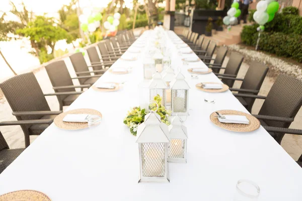 Düğünde uzun bir yemek masası. Açık hava düğününde masa örtüleriyle süslemeler..