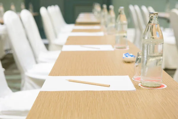 Papel Lápiz Botella Agua Vidrio Sobre Mesa Fondo Sala Seminarios Imagen De Stock