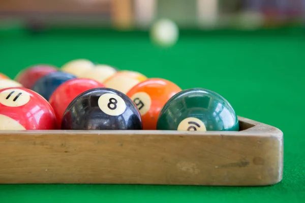 Selective focus of Colorful pool balls on green pool table.