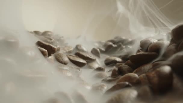 Pomalá panenka na záběrech u pražených kávových zrn s kouřem, čerstvě uvařená kávová zrna s kouřem leží na stole. extrémní makro záběr zrn pro výrobu kávy nápoj. — Stock video