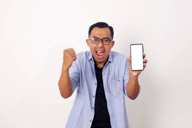 Boş cep telefonu ekranı gösteren ve hayret içinde kameraya bakan sıradan Asyalı bir adamın portresi. Beyazda izole edilmiş