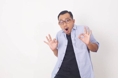 Etkileyici genç yakışıklı, sıradan Asyalı adam iyi bir jest yapıyor. Beyaz arkaplanda izole