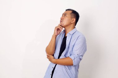 Asyalı genç bir adamın portresi beyaz arka planda soyutlanmış bir şekilde yukarı bakıyor.