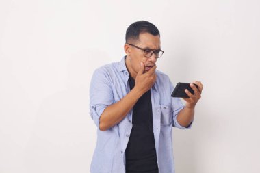 Asyalı adam cep telefonuna bakarken şok oldu. Beyaz arkaplanda izole