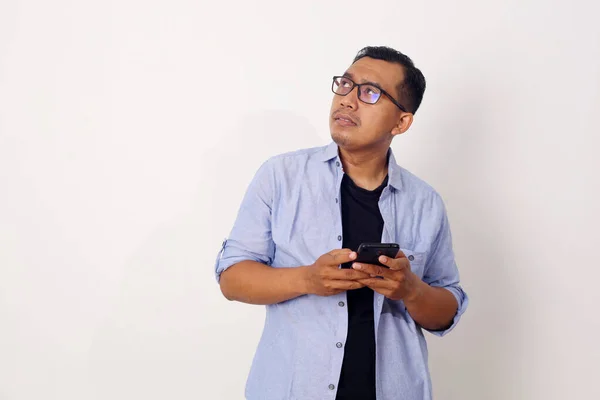 Porträtt Omtänksam Asiatisk Man Stående Och Hålla Mobiltelefon Isolerad Vit — Stockfoto