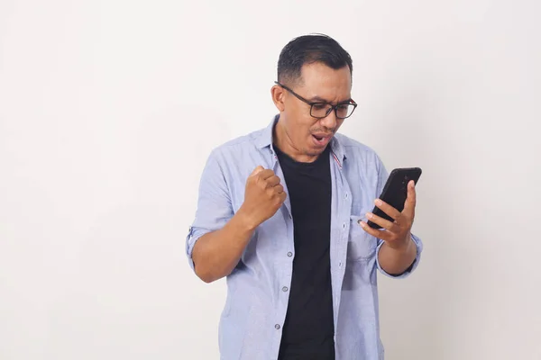 Homem Asiático Alegre Enquanto Olha Para Telefone Celular Isolado Sobre — Fotografia de Stock